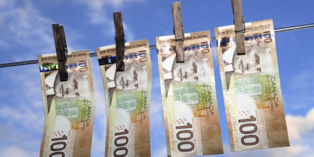 Canadian $100 banknotes hanging from a washing line - concept of money laundering. Note, banknotes have been altered from ori