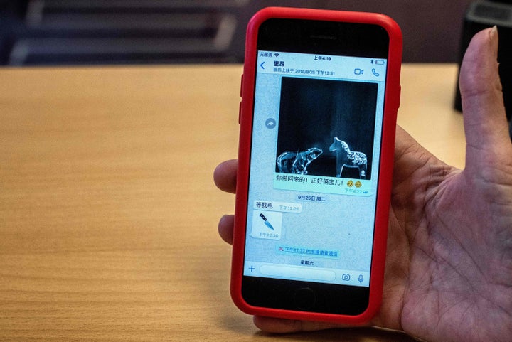 A journalist holds the mobile phone of Grace, the wife of the missing Interpol president Meng Hongwey, showing the last message exchanged with her husband.