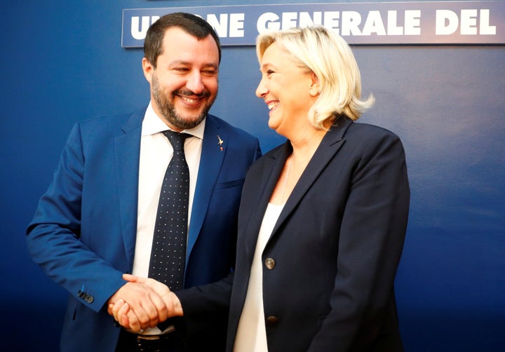 Marine Le Pen and Matteo Salvini shake hands before holding a news conference in Rome on Oct. 8.