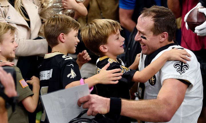 Brees hugs his family after breaking the NFL all-time passing record on Monday night.