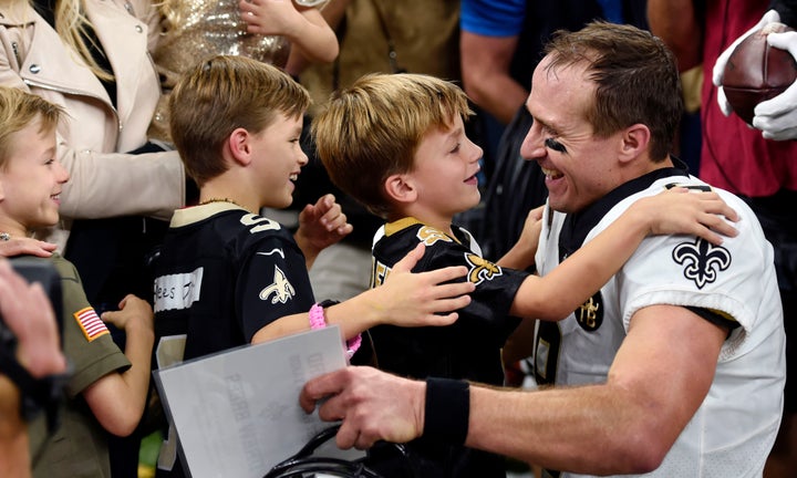 Brees hugs his family after breaking the NFL all-time passing record on Monday night.<i></i>