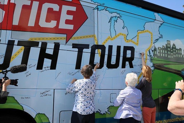 People sign the Network Lobby bus that will be heading to 21 states over the course of 27 days.