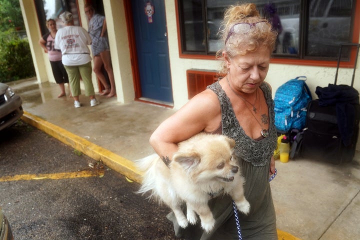 Lenora Adams loads up her dog as she evacuates a motel in Panacea, Florida, on Oct. 10.