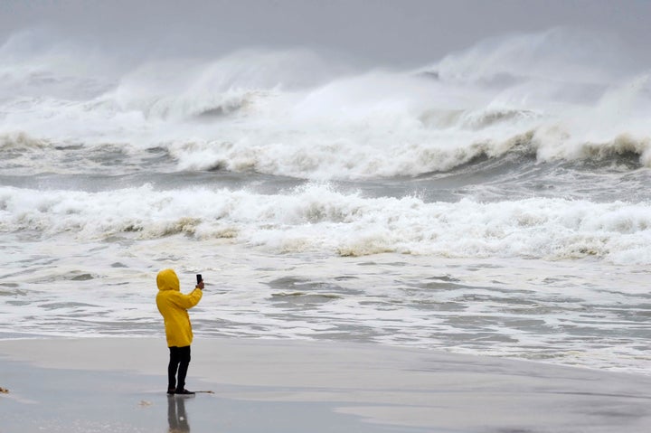 An unidentified person takes pictures of the surf and fishing pier on Okaloosa Island in Fort Walton Beach, Florida, on Oct. 10.