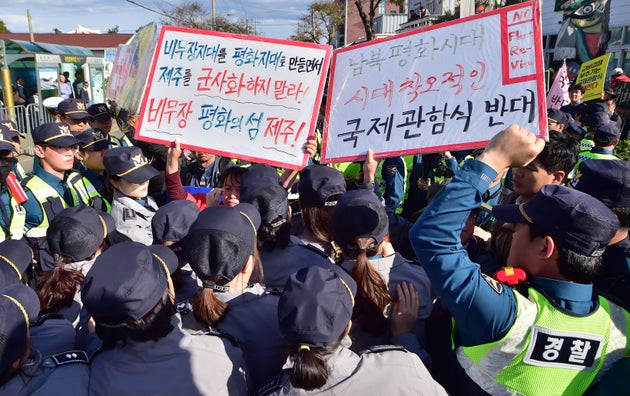 11일 오후 제주 서귀포시 강정마을 커뮤니티센터 인근 사거리에서 '2018 해군 국제관함식 반대와 평화의 섬 제주 지키기 공동행동'과 전국민주노동조합총연맹 관계자들이 경찰들과 대치하고 있다.