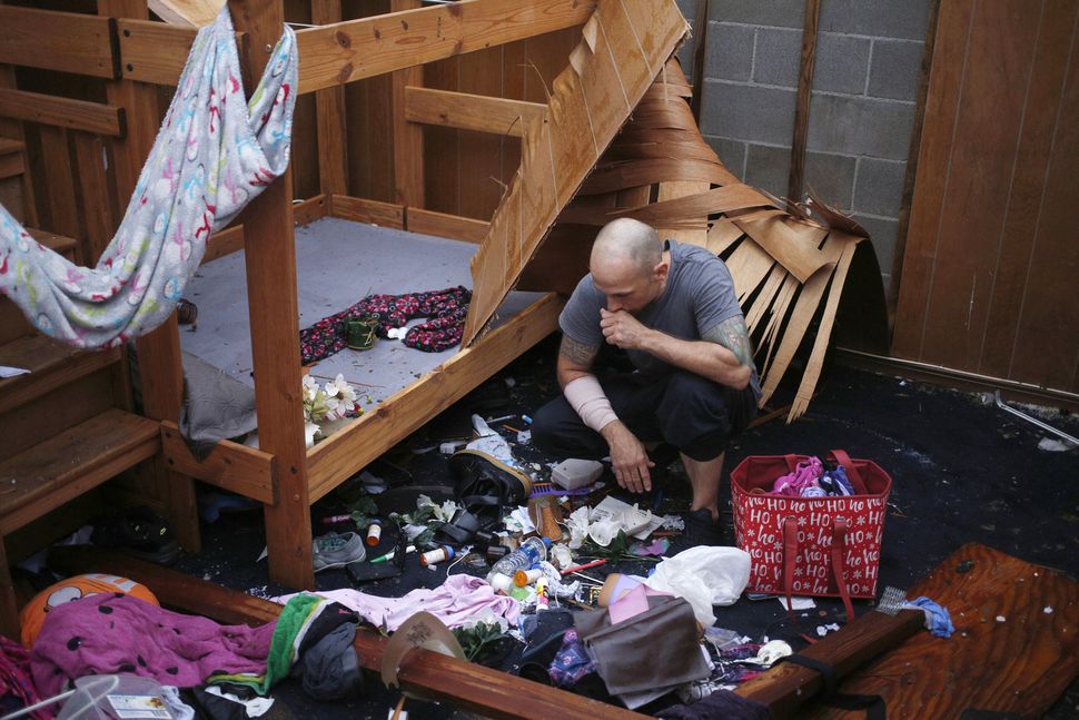 A resident looks at belongings scattered on a floor at a damaged home in Panama City.