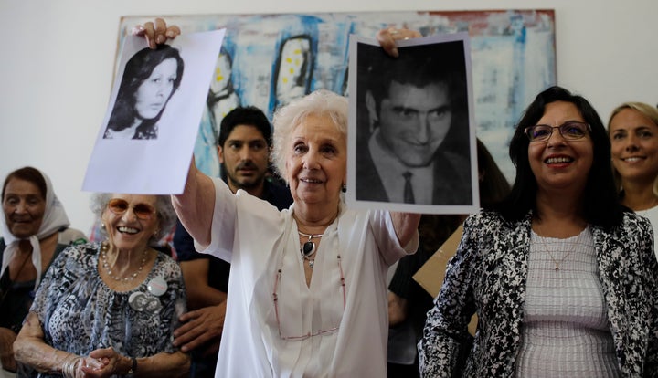 A woman holds pictures of two people who were disappeared while being held as political prisoners during Argentina’s military dictatorship.