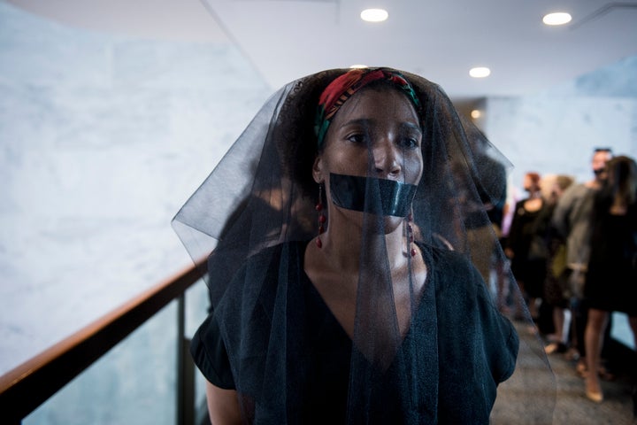 A group of women wear black veils and black tape over their mouths outside of the fourth day of Brett Kavanaugh's hearing before members of the Senate Judiciary Committee on Sept. 7, 2018.