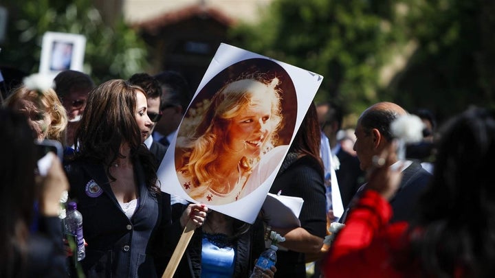 A woman holds a photo of Marsy Nicholas, whom Marsy’s Law was named for, during a 2013 victims’ rights march and rally in San