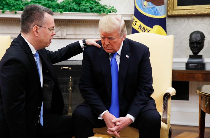 President Donald Trump prays with American pastor Andrew Brunson in the Oval Office of the White House.