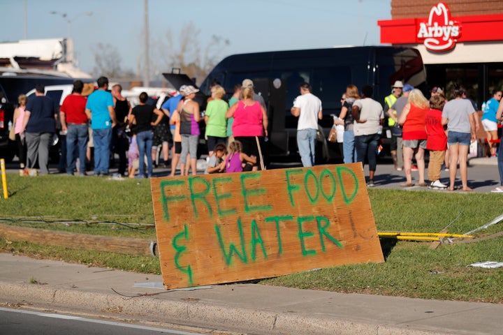 People line up for free food and water in the aftermath of Hurricane Michael in Panama City, Fla., Saturday, Oct. 13, 2018. (AP Photo/Gerald Herbert)