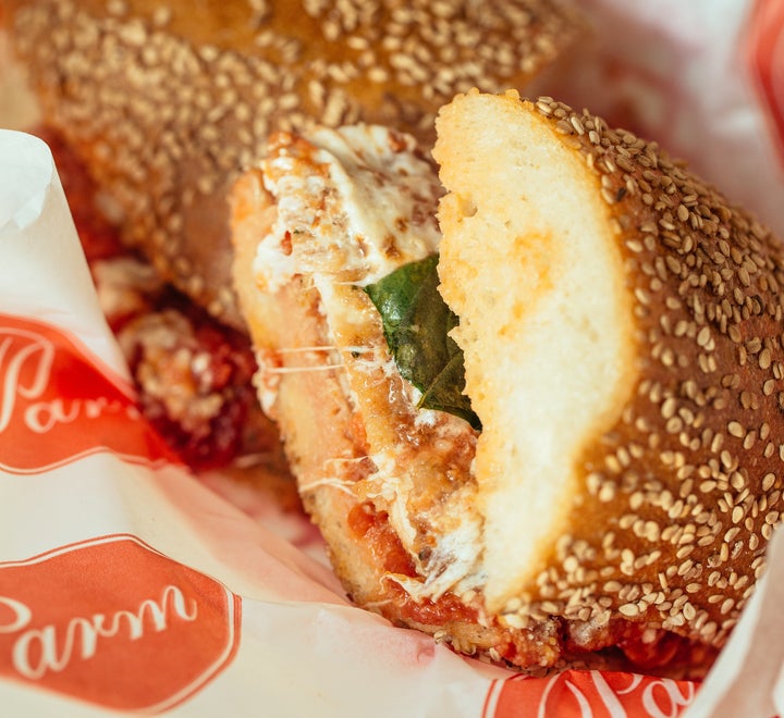 The chicken parm sandwich from Parm is a breaded, enormous hunk of chicken covered in overflowing, melty mozz and red sauce.