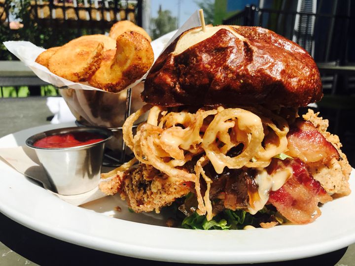 The South Bound Dump Truck, a fried chicken sandwich with lettuce, tomato, bacon, onion jam and Tabasco maple mayo on a pretzel bun.