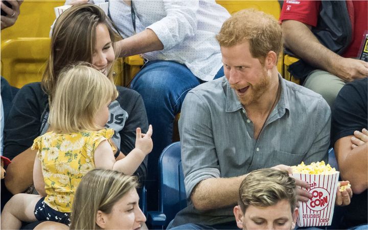 Prince Harry goofs around with a child trying to steal his popcorn at the Invictus Games on Sept. 28, 2017. 