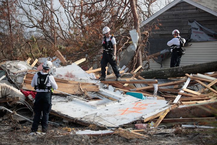 Members of the Maryland Task Force urban search and rescue team mark a location for a detailed search after getting a reaction from their cadaver dog indicating a possible victim of Hurricane Michael on October 16, 2018 in Mexico Beach, Florida. (Photo by Scott Olson/Getty Images)