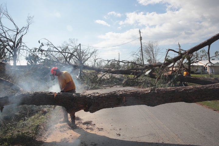 Frank Barone cuts up a tree which was downed by Hurricane Michael and blocking a residential street on October 14, 2018 in Panama City, Florida.