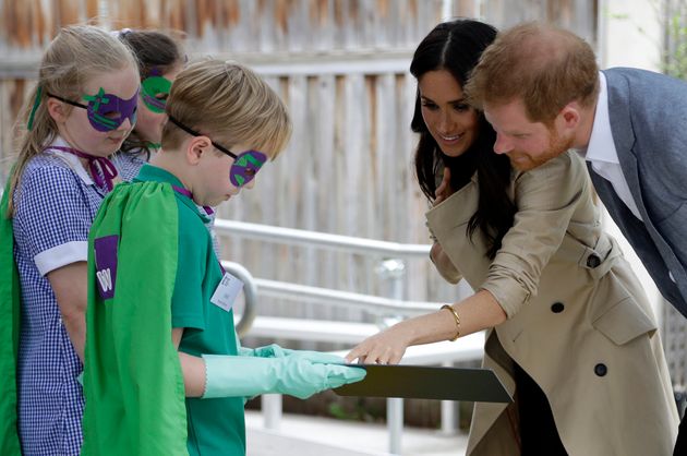 Prince Harry and Meghan chat to children dressed up in superhero costumes. 