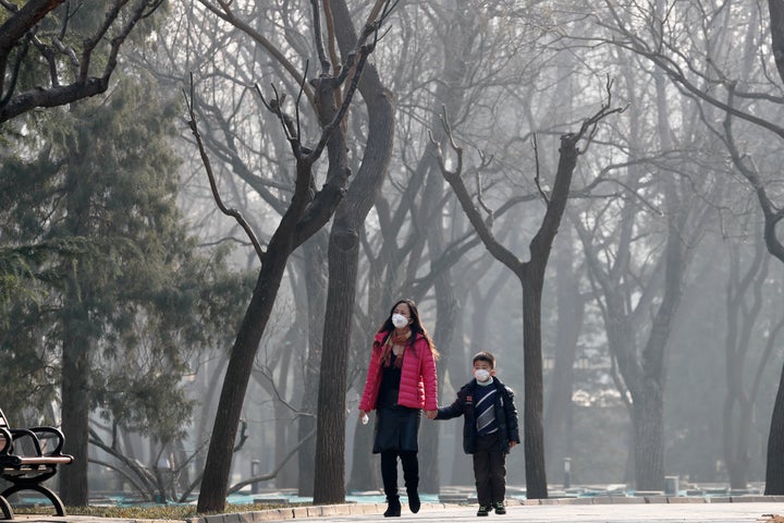 A woman and a child wearing masks to protect against pollution in Ritan Park, Beijing. Despite it's huge economic growth, Chi