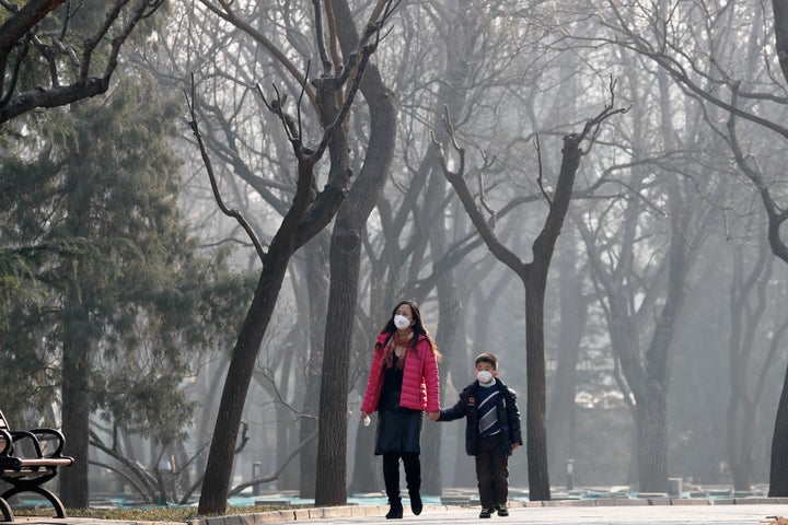 A woman and a child wearing masks to protect against pollution in Ritan Park, Beijing. Despite it's huge economic growth, China is facing enormous environmental problems.