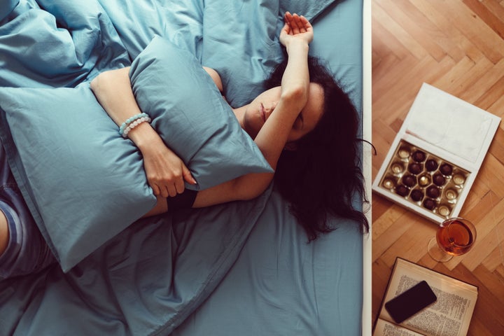 Depressed woman in bed with hand on face