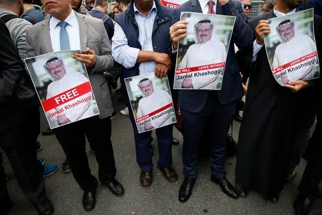 Members of the Turkish-Arab journalist association hold posters with photos of the missing Saudi writer