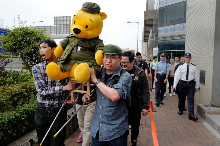 Protesters carry a Winnie the Pooh dressed as Communist Party member to symbolize Chinese President Xi Jinping in Hong Kong on March 18, 2018.