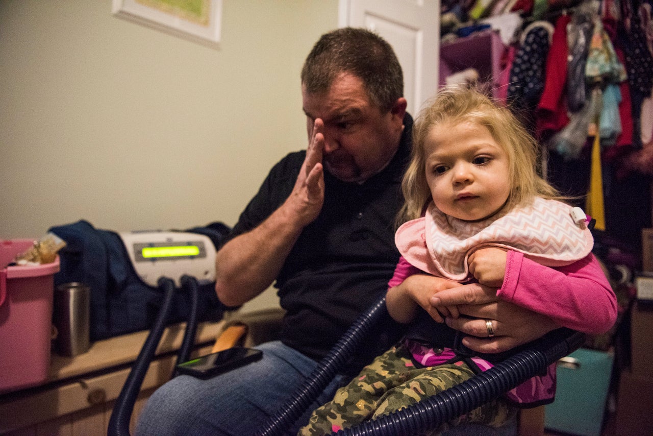 Tom cries as he gives his daughter Willow her daily lung treatment. "Rocket Man" plays in the background.