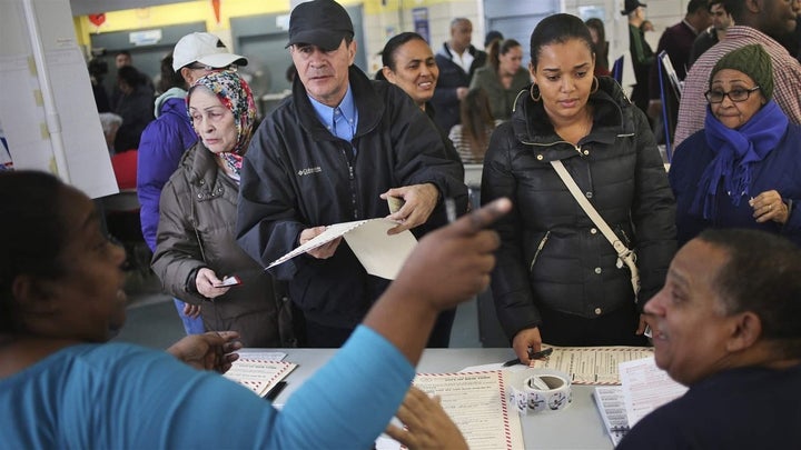 Poll workers direct voters at a New York polling station during the 2016 presidential election. Poll workers are older, less prepared and becoming scarcer.