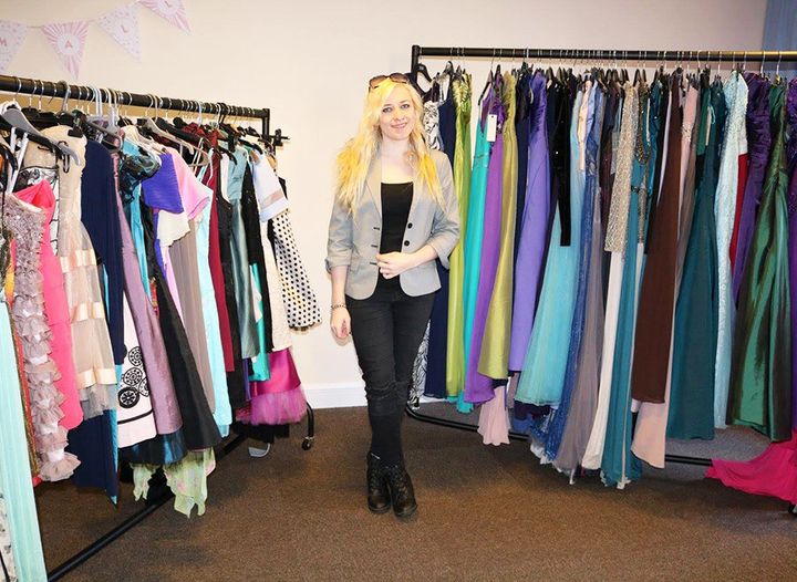 Ally surrounded by prom dresses.