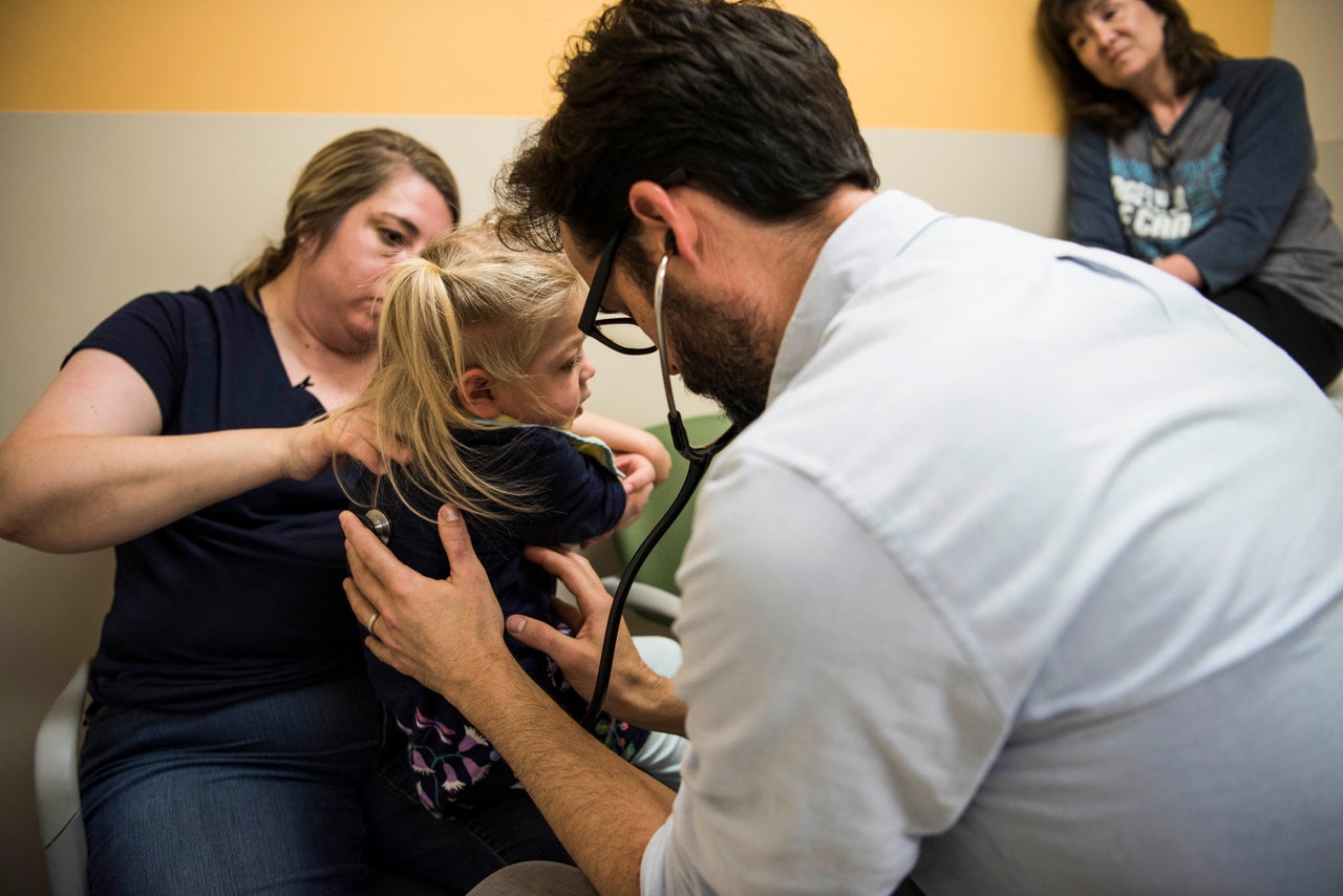 Amber holds Willow while Dr. Brian Kirmse carefully listens to her breathing at the University of Mississippi Medical Center.