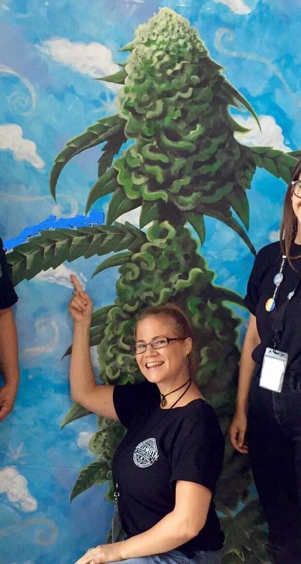 The author in front of a mural she created at the dispensary where she worked.