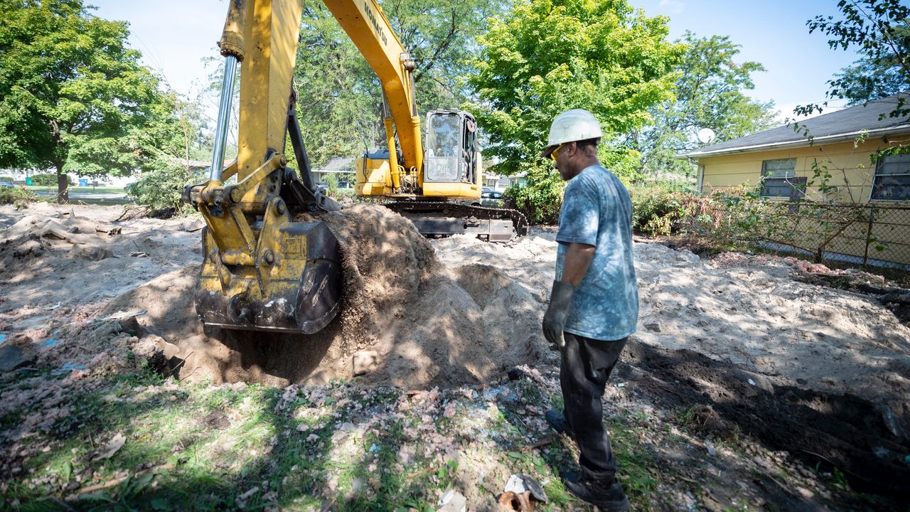 Kenneth "Rabbit" McCoy watches as John Schiralli, owner of Aavatar Enterprises, operates a backhoe to remove debris from one of the homes they've been contracted to demolish on Sept. 19, 2018.