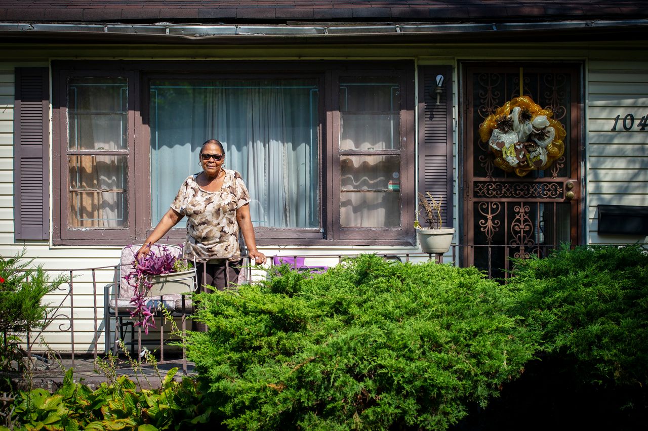 Ida Sain, 75, stands on the front porch of her house on Sept. 19, 2018. It's been her home since 1972. Behind her property, abandoned homes were demolished -- part of Gary, Indiana's program to tear down vacant structures.