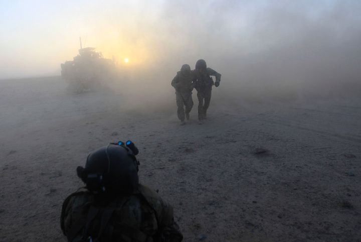 A U.S. Army flight crew chief sergeant helps a wounded soldier to a medevac helicopter after he was hit in a roadside bomb in in the Helmand Province of southern Afghanistan on Sept 11, 2011.