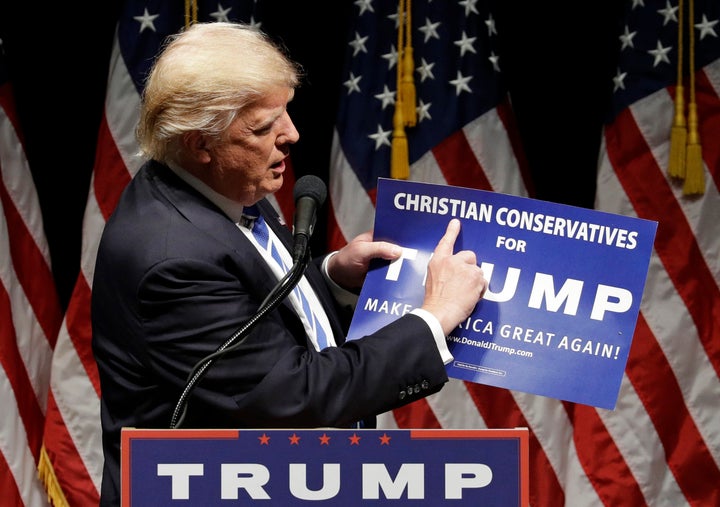 Then-presidential candidate Donald Trump holds up a "Christian Conservatives for Trump" sign at a rally on Sept. 28, 2016, in Council Bluffs, Iowa.