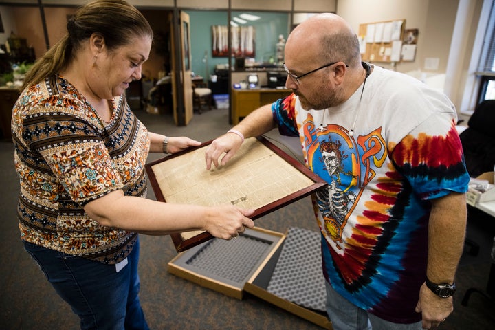 Goodwill employees Heather Randall and Mike Storms look over a Dec. 28, 1774 Pennsylvania Journal and the Weekly Adverti