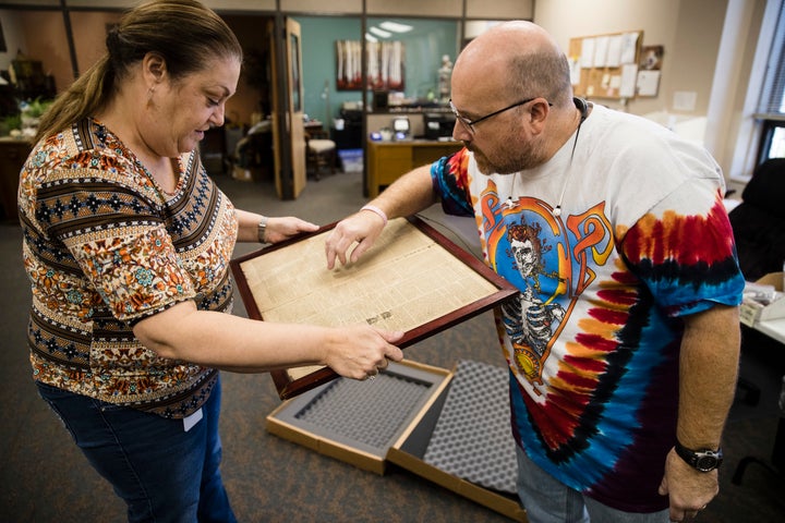 Goodwill employees Heather Randall and Mike Storms look over a Dec. 28, 1774 Pennsylvania Journal and the Weekly Advertiser.