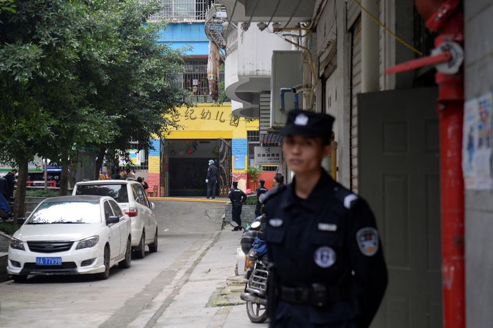 Police officers are seen outside the gate of a kindergarten where a woman armed with a kitchen knife attacked children, in Chongqing, China 