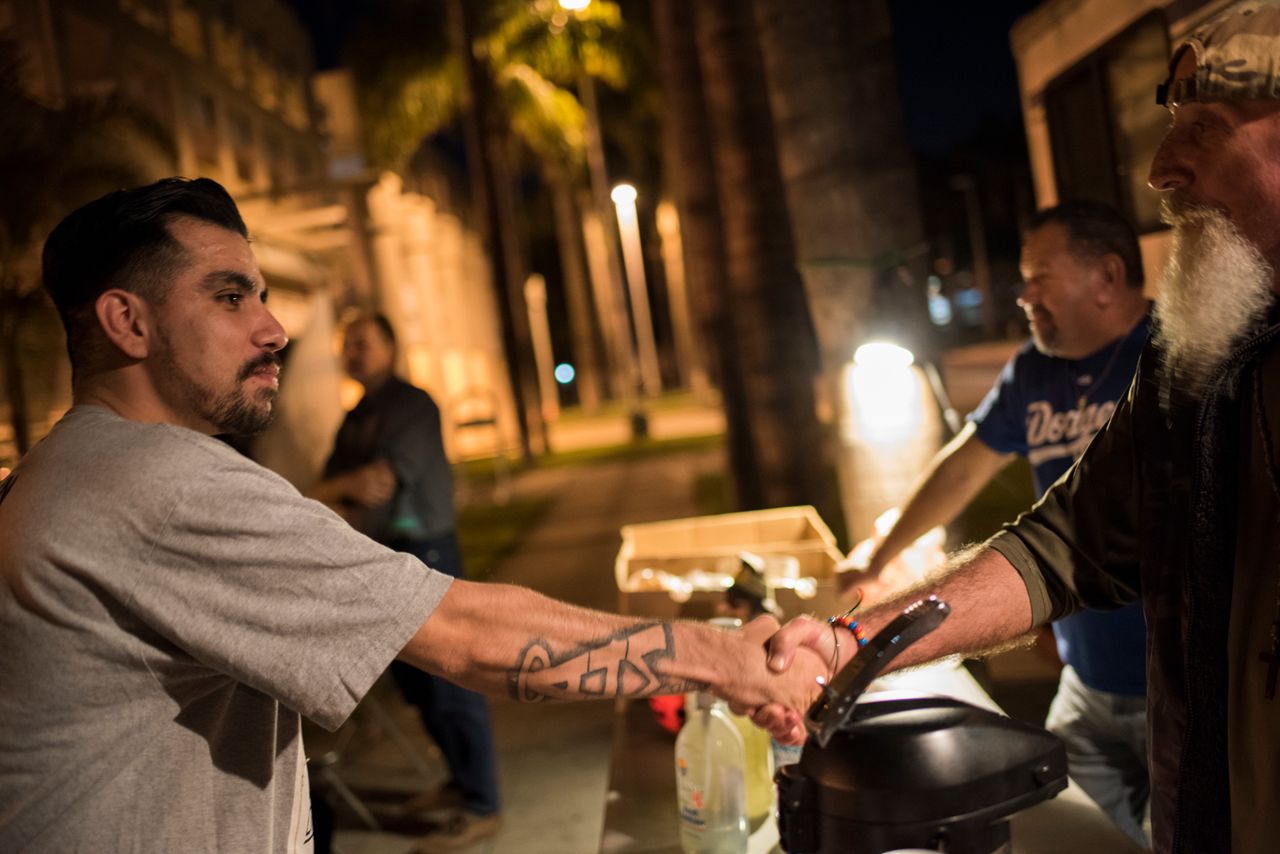 On Friday nights, the ACLU partners with Micah's Way, an organization serving Orange County's homeless population. The group parks its RV outside of the jail and offers coffee, pizza and cell phone charging to inmates who were just released. Micah's Way board president Vaskin Koshkerian, right, shakes hands with Ricardo Campos, 27, who stopped by the RV for a cup of coffee.