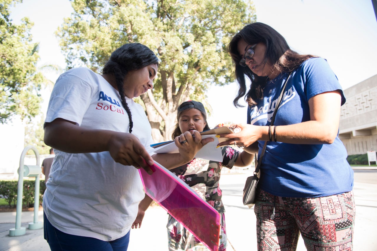 ACLU volunteer Christy Guadarrama, left, helps Jessica Coronado, 26, fill out the paperwork while registering to vote in California. 