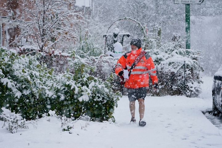 A postman in shorts delivers mail in the snow near Consett, County Durham.