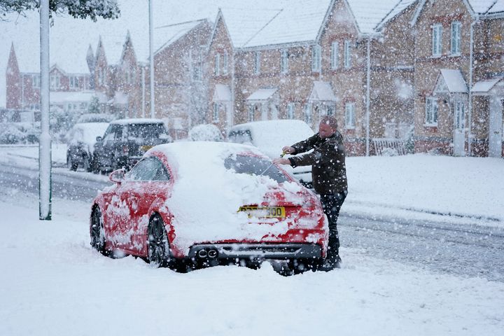 A man clears the snow off his car near Consett, County Durham.