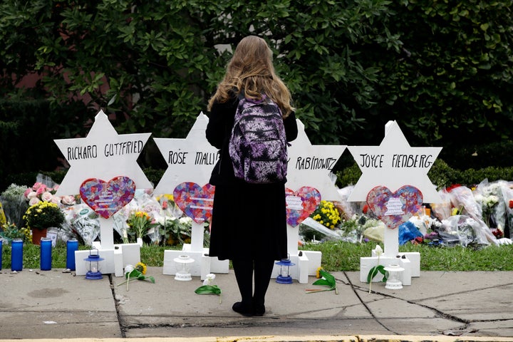 A person stands in front of Stars of David that are displayed in front of the Tree of Life Synagogue with the names of those killed in Saturday's deadly shooting in Pittsburgh, Monday, Oct. 29, 2018. (AP Photo/Matt Rourke)