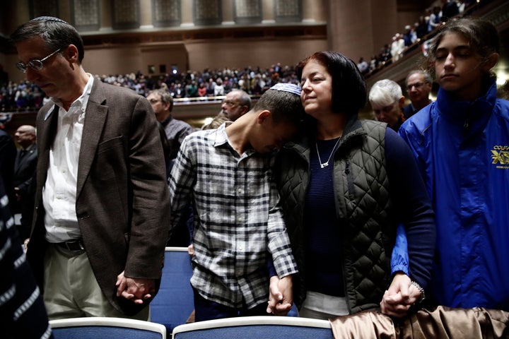 People mourn the 11 victims of the Tree of Life synagogue shooting during a vigil at Soldiers and Sailors Memorial Hall in Pi