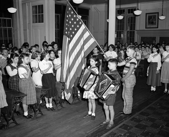 Two recently immigrated children from Romania play "The Star-Spangled Banner" at a special assembly marking the opening of a school in New York City on Sept 11, 1950. The children and their parents were helped by HIAS, according to AP.