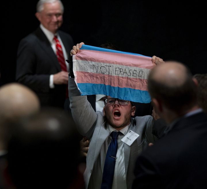 A third protester held up a transgender pride flag while yelling, “We will not be erased!”