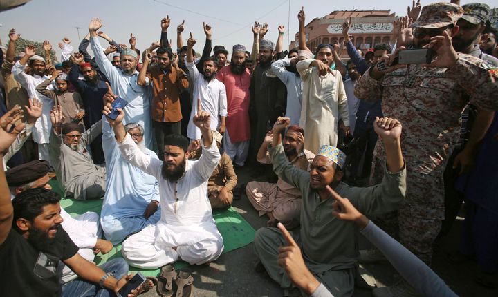 Supporters of a Pakistani religious group in Karachi chant slogans while blocking a main road at a protest after the courts decision