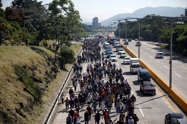 People walk in a caravan of migrants departing from El Salvador en route to the United States, in San...