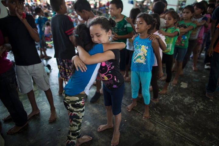 Honduran girls hug while waiting in line for a chance to play on the playground at a camp set up by a caravan of thousands of Central American migrants in Juchitan, Mexico, on Wednesday.