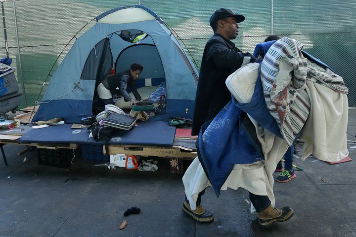 A homeless couple gather their belongings at a tent camp in San Francisco. Half the money that the newly passed Proposition C generates will go toward building permanent housing for homeless residents.